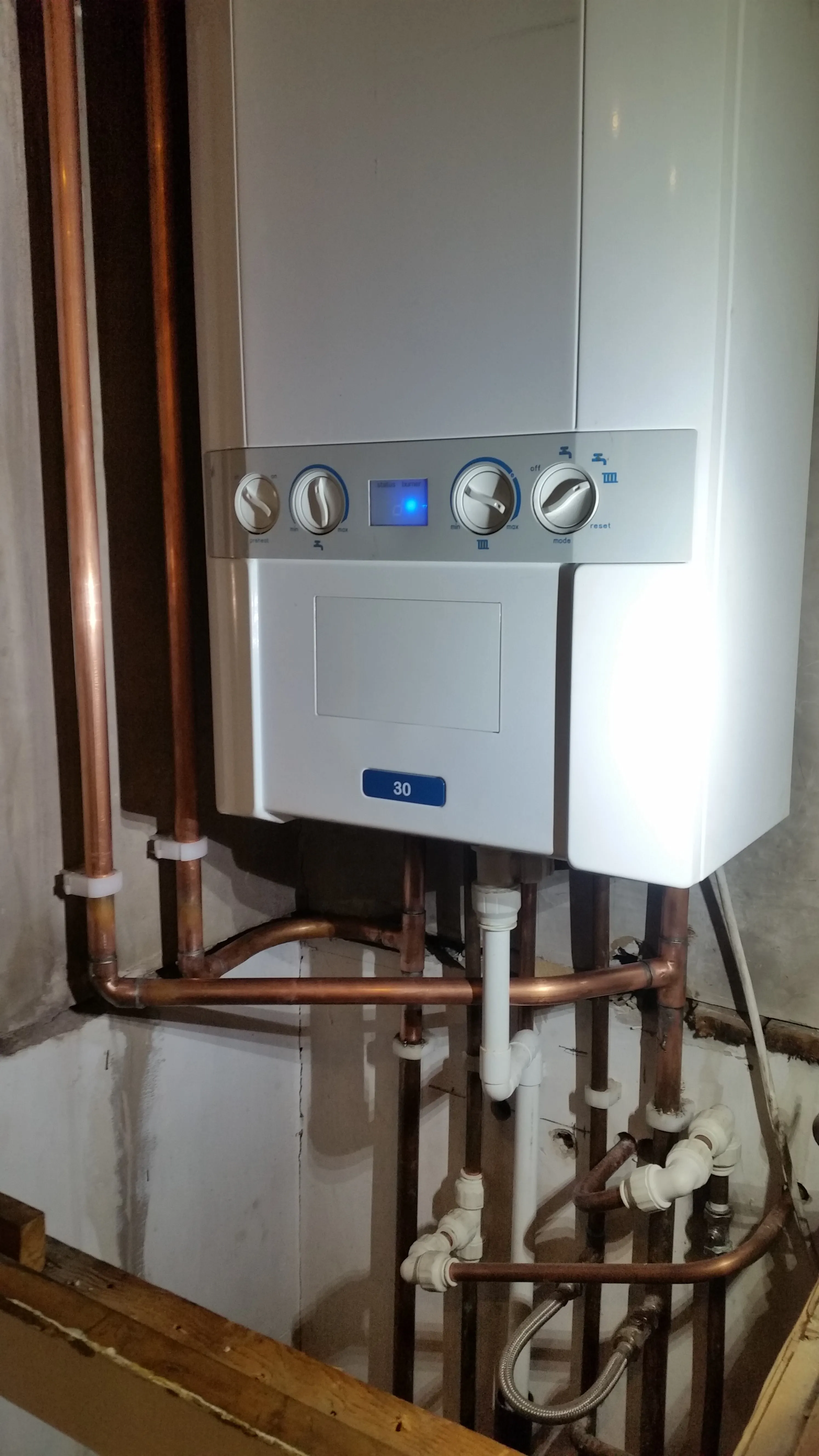 A wall-mounted gas boiler with visible pipework