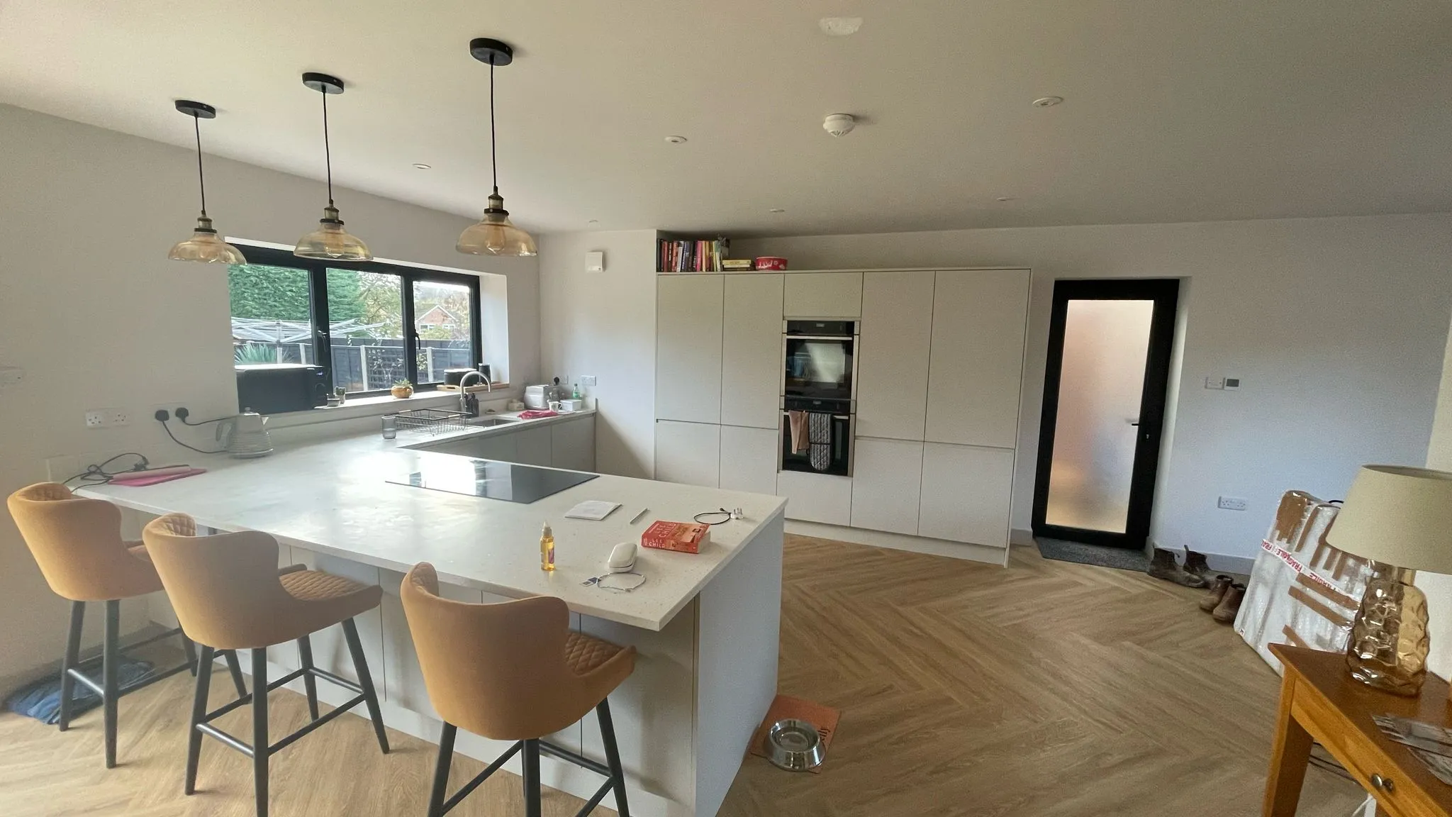 Bespoke modern kitchen design and installation featuring a central island and herringbone flooring in Cheltenham