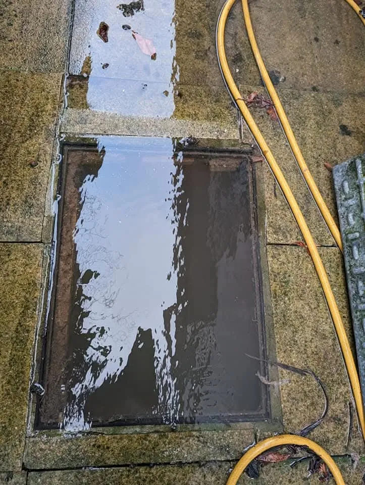 Blocked outdoor drain overflowing onto pavement