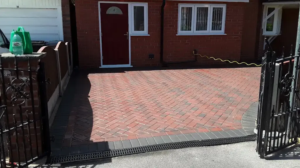 Newly installed block paved driveway with dark grey border and drainage channel.