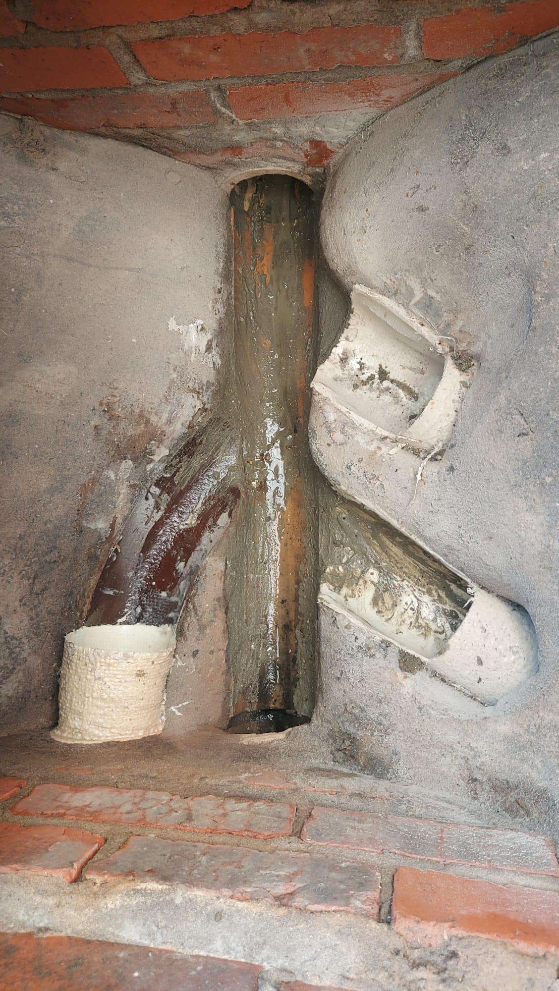 Severely damaged and misaligned drain pipes within an inspection chamber, highlighting the need for expert collapsed drain repair services in Torquay and the wider Torbay area.