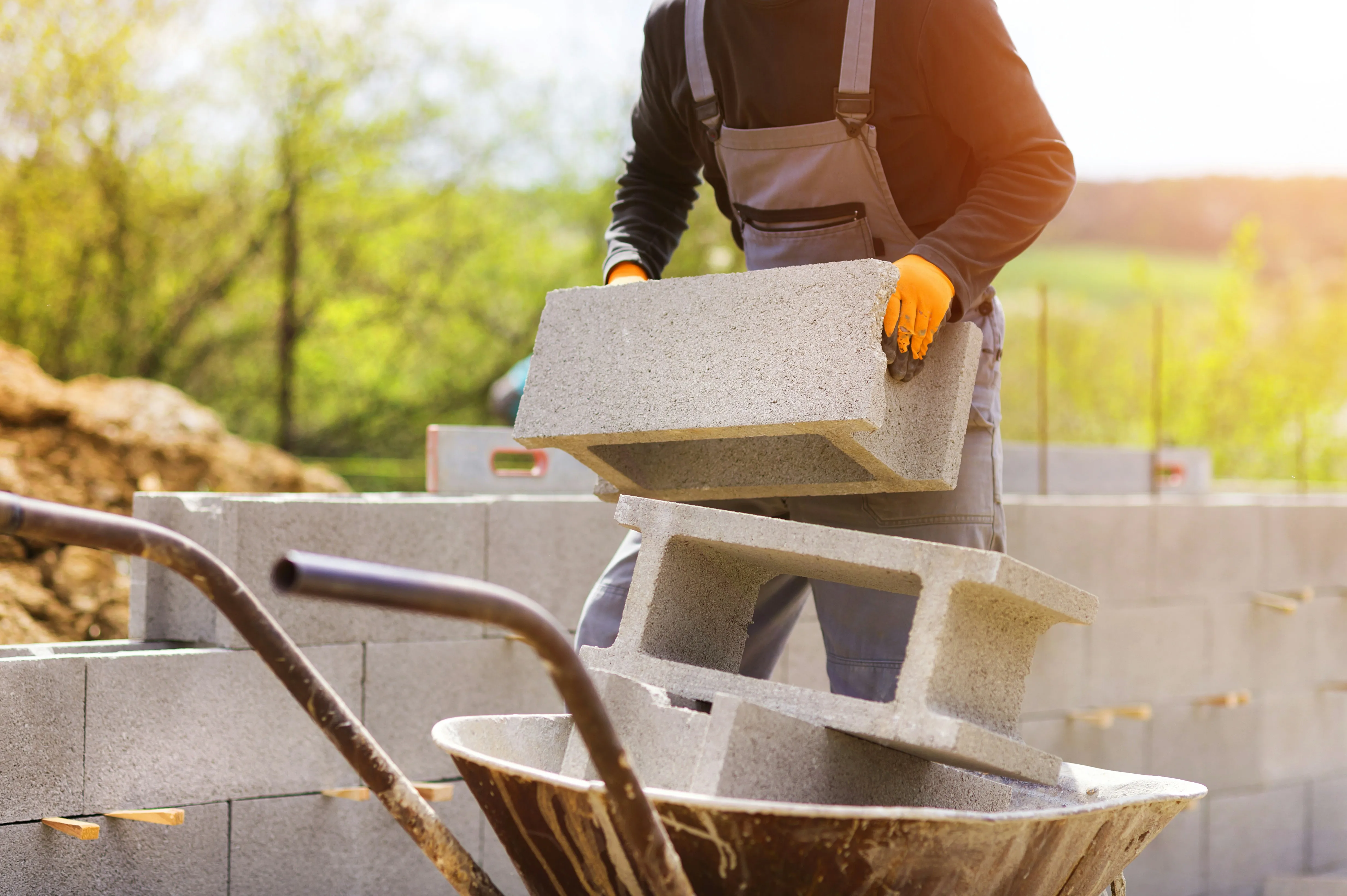 Professional builder handling concrete blocks on a building site in Haywards Heath area.