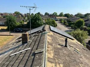 Old and damaged residential pitched roof requiring repair or a new roof installation.