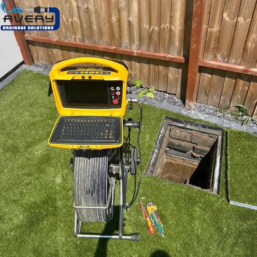 CCTV drain survey equipment beside an open manhole