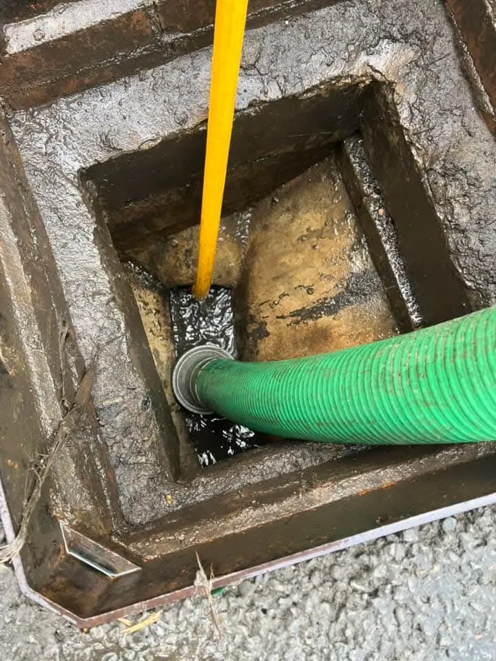 Drainage hose and cable in a manhole.