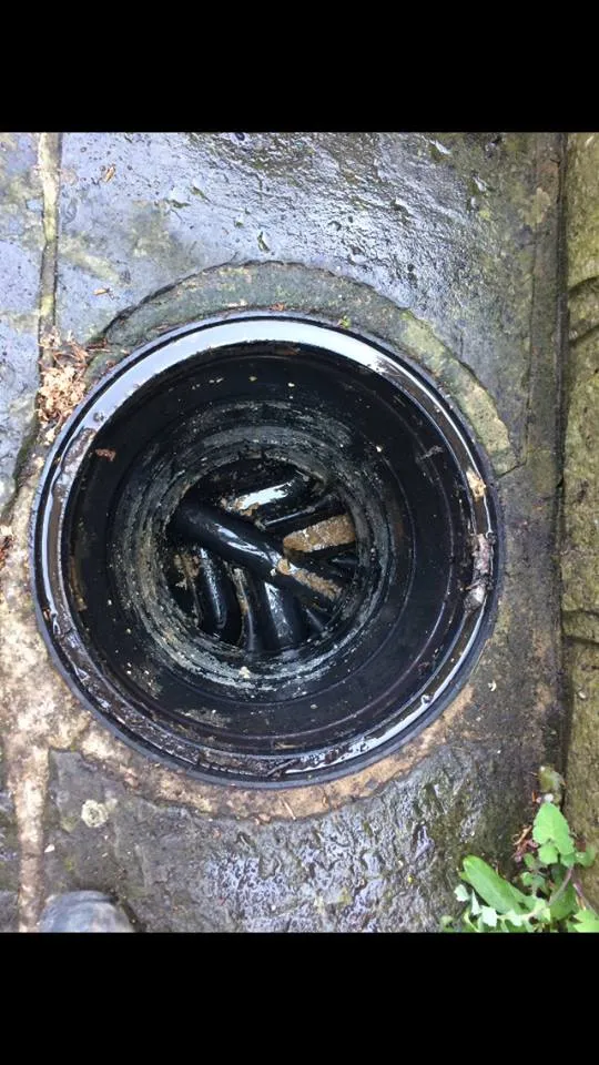 Blocked outdoor drain gully with visible debris and grime
