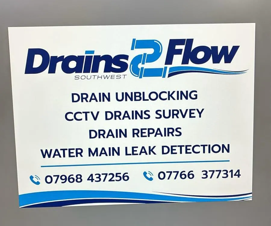 Drains2Flow Southwest sign advertising drain unblocking, CCTV drain surveys, drain repairs, and water main leak detection services, with two contact phone numbers.