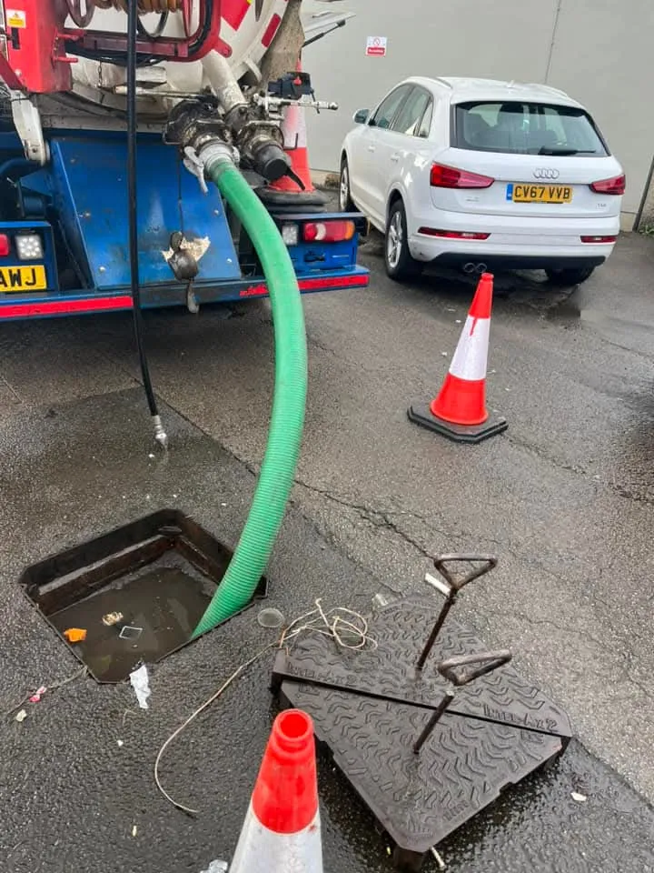 Drain King engineers clearing a blocked manhole during a drainage job.
