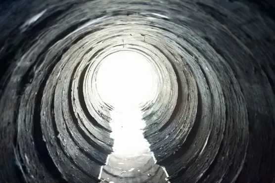 View from inside a drain pipe, showing a clear pathway and bright light at the end, representing a successful unblock or a CCTV drain survey.