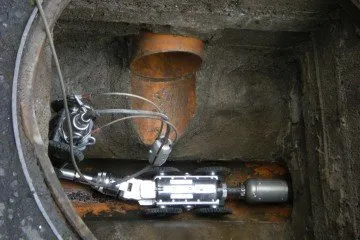 A CCTV drain inspection camera inside a manhole