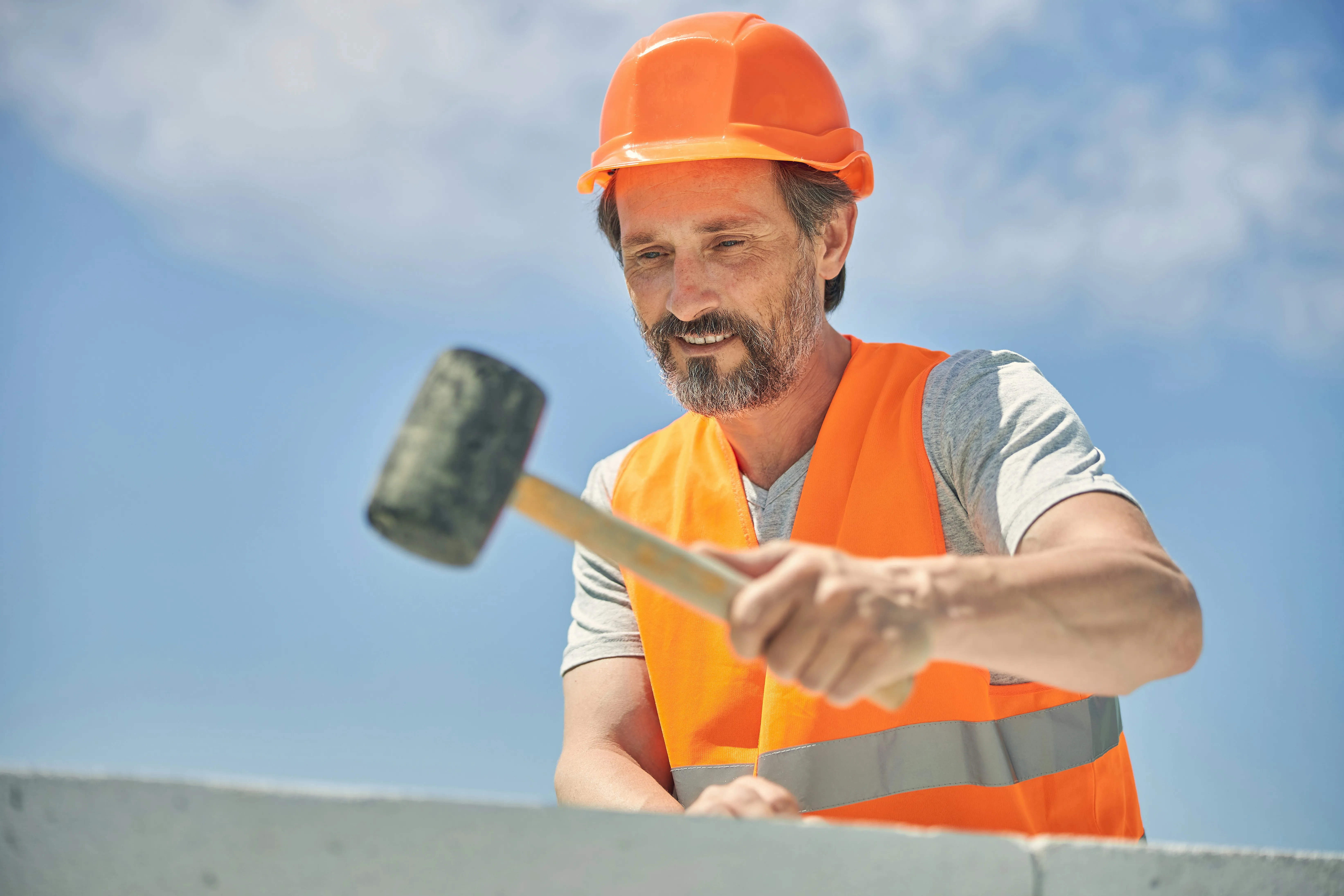 Skilled construction worker using a mallet on building blocks during a home renovation project in Haywards Heath.