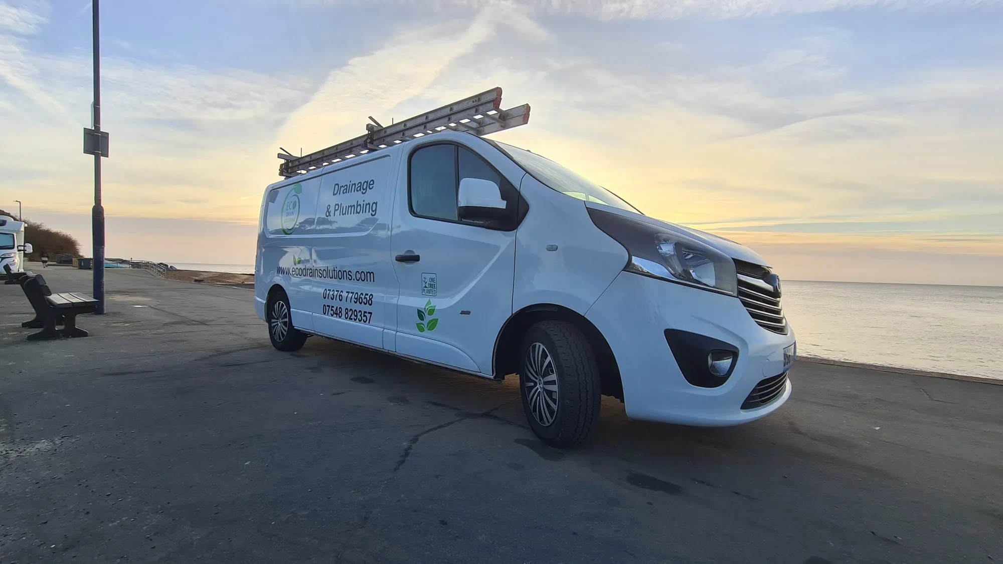 Eco Drain Solutions Ltd branded service van parked on a coastal path next to the sea, reflecting the company's drainage and plumbing services and their commitment to environmental sustainability.