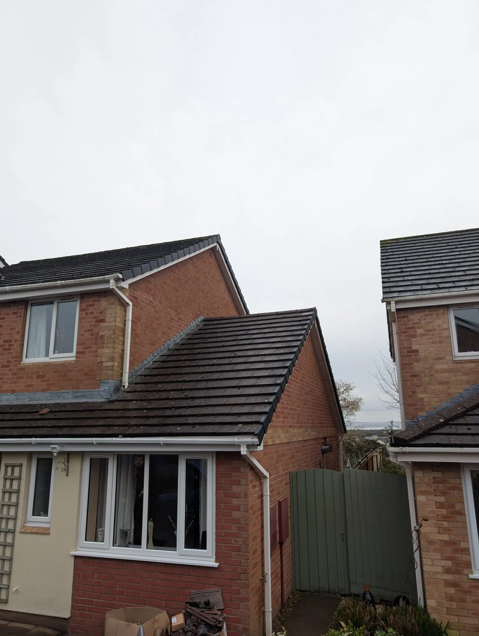 Residential properties showcasing dark tiled roofs, white uPVC guttering, and fascias, representative of local roofing and roofline services.