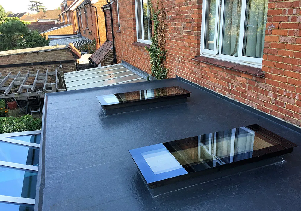 Newly installed dark grey flat roof with modern rooflights
