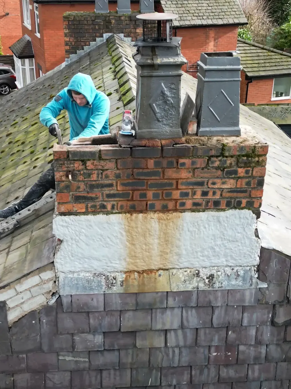 Roofer repairing a brick chimney and roof tiles in Manchester.
