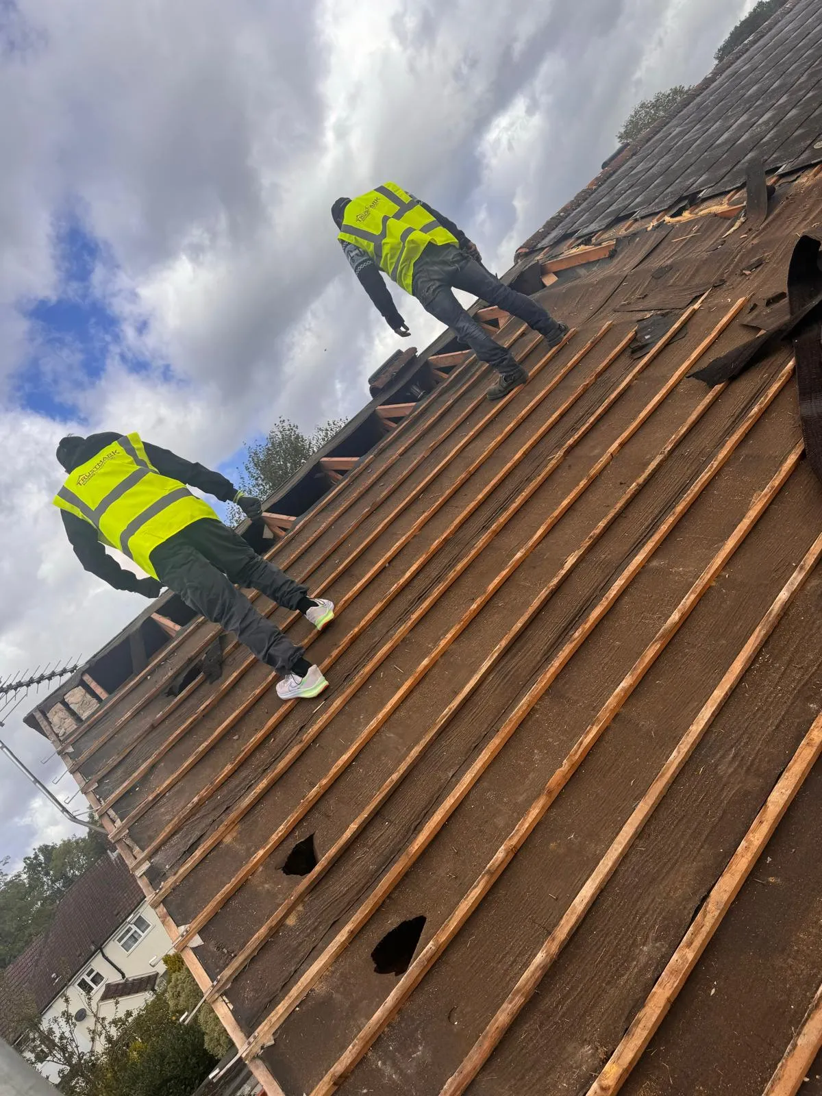 Two Trustmark Roofing team members installing battens and underlay for a new pitched roof.