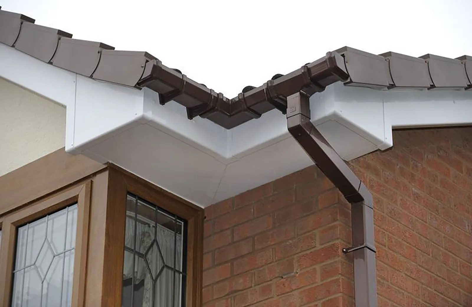 Brown guttering, white fascias and soffits on a house corner