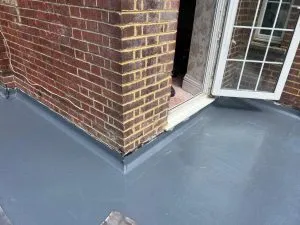 A newly installed grey flat roof on a residential building, demonstrating high-quality flat roofing services.