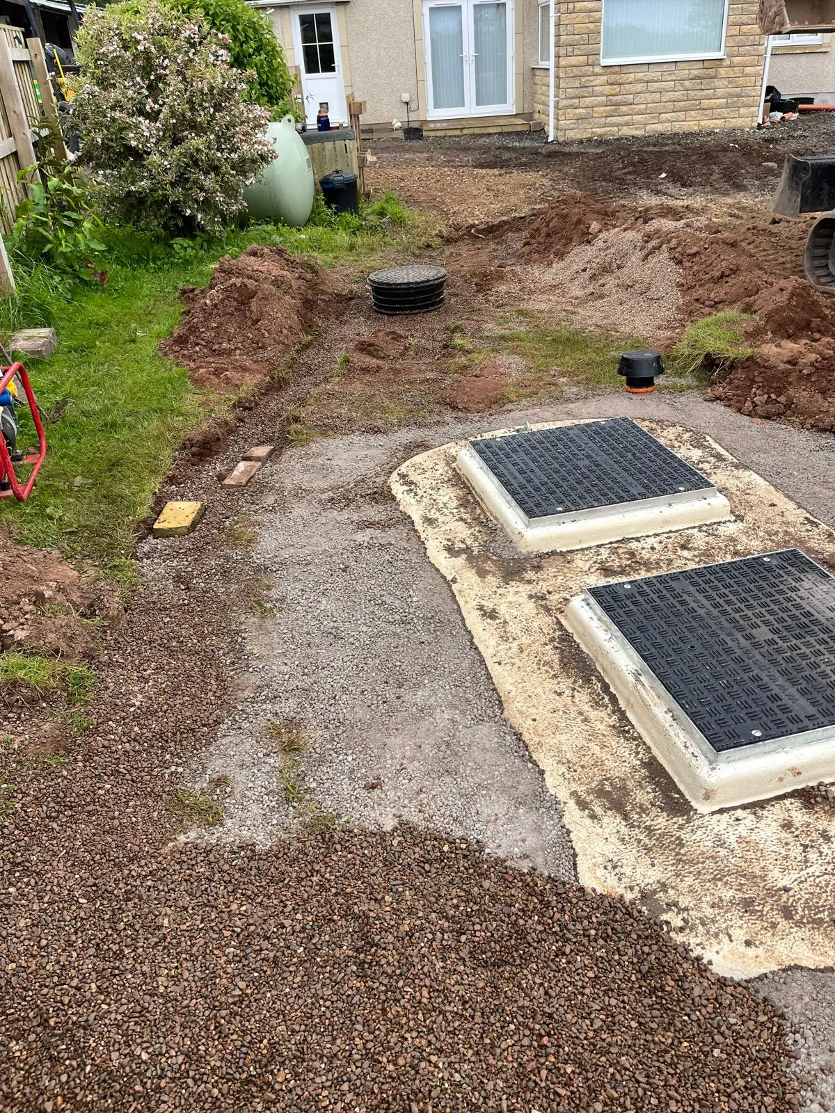 Groundwork for a septic tank and drainage system installation in a garden