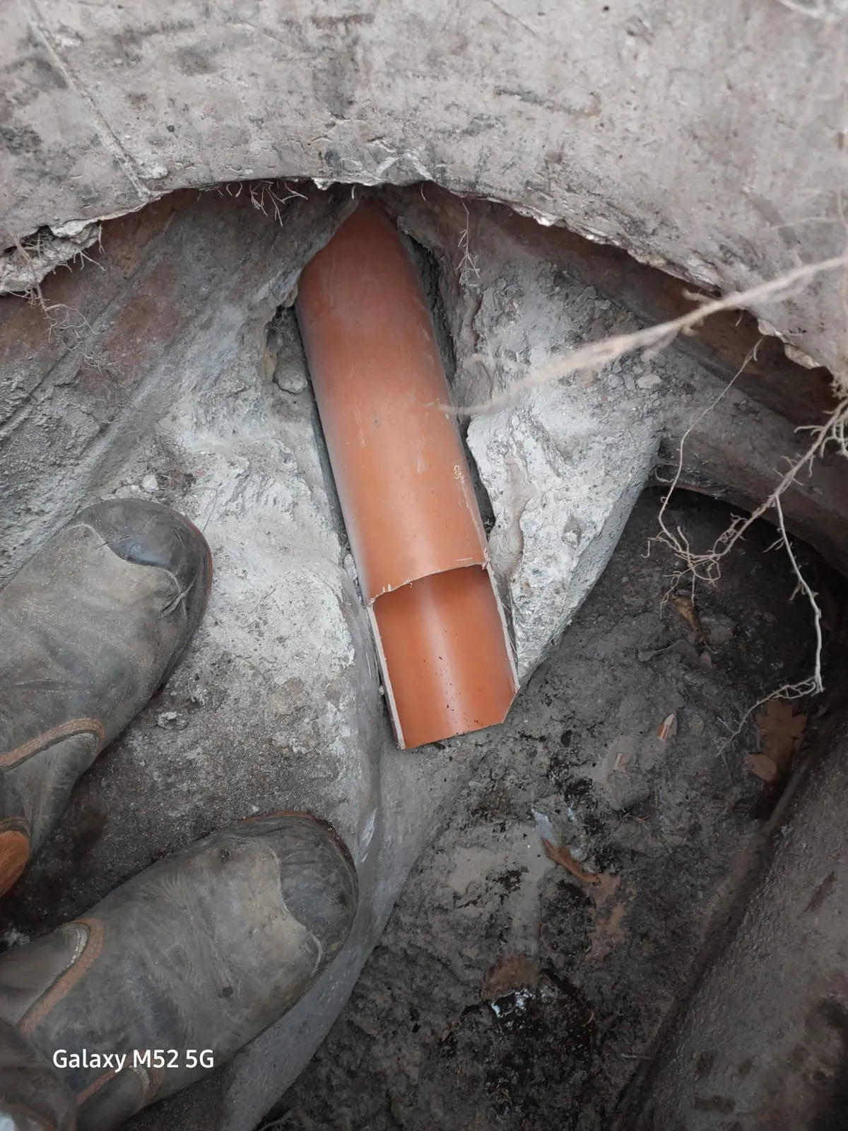 Drainage pipe being repaired or installed in an excavated trench.