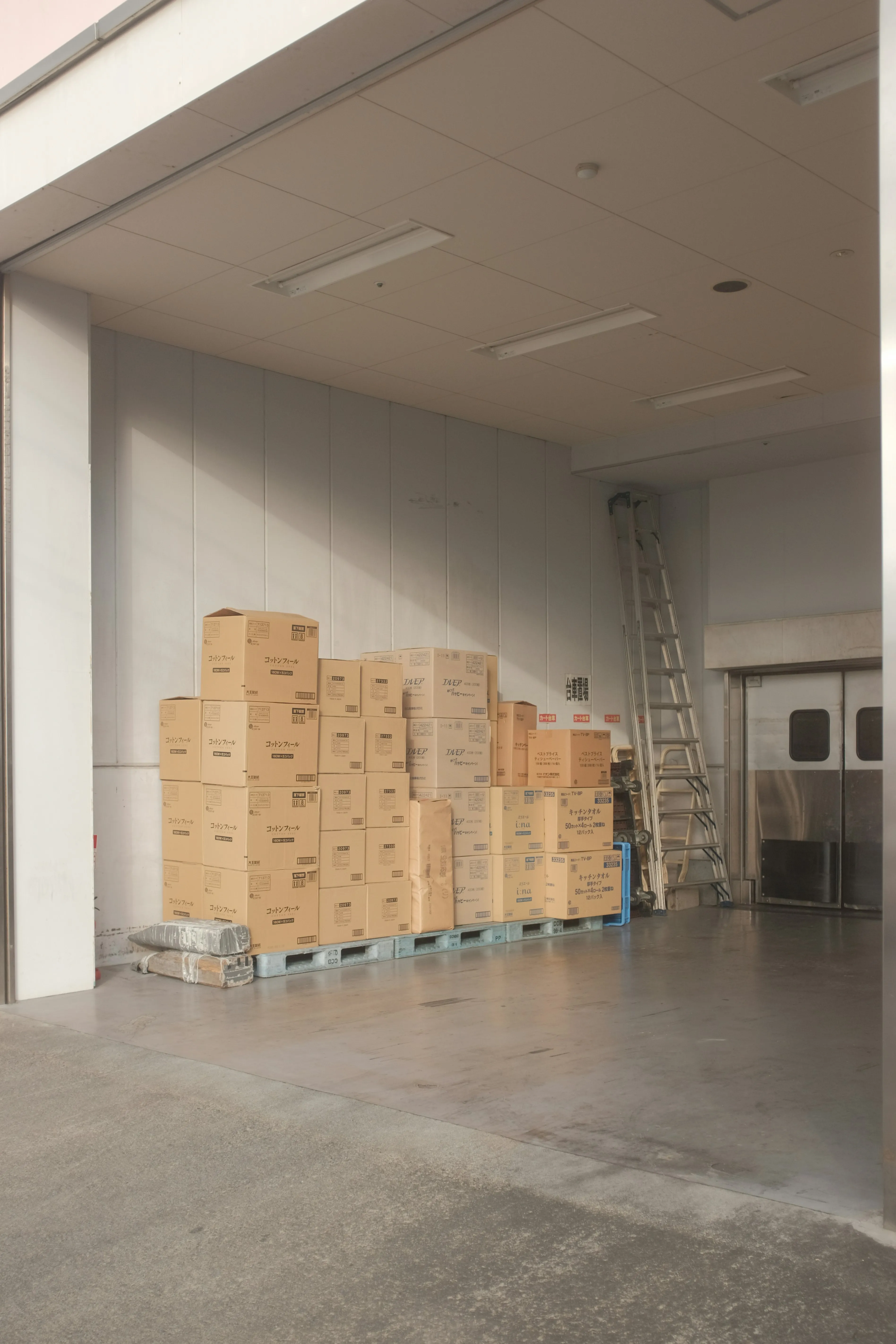 Stack of moving boxes on a pallet inside a warehouse.