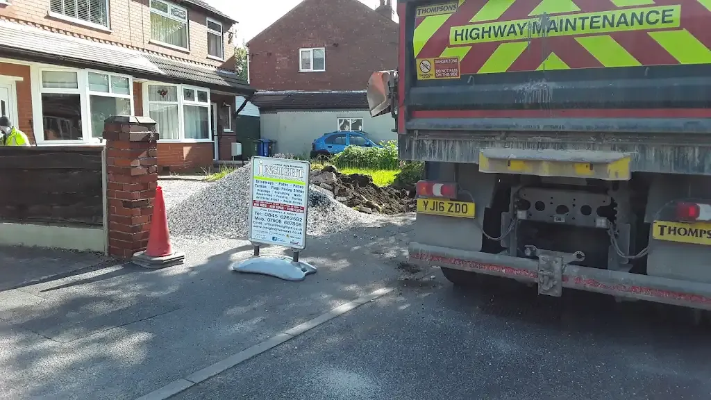 Groundwork and material delivery for a driveway or paving project in front of a house.