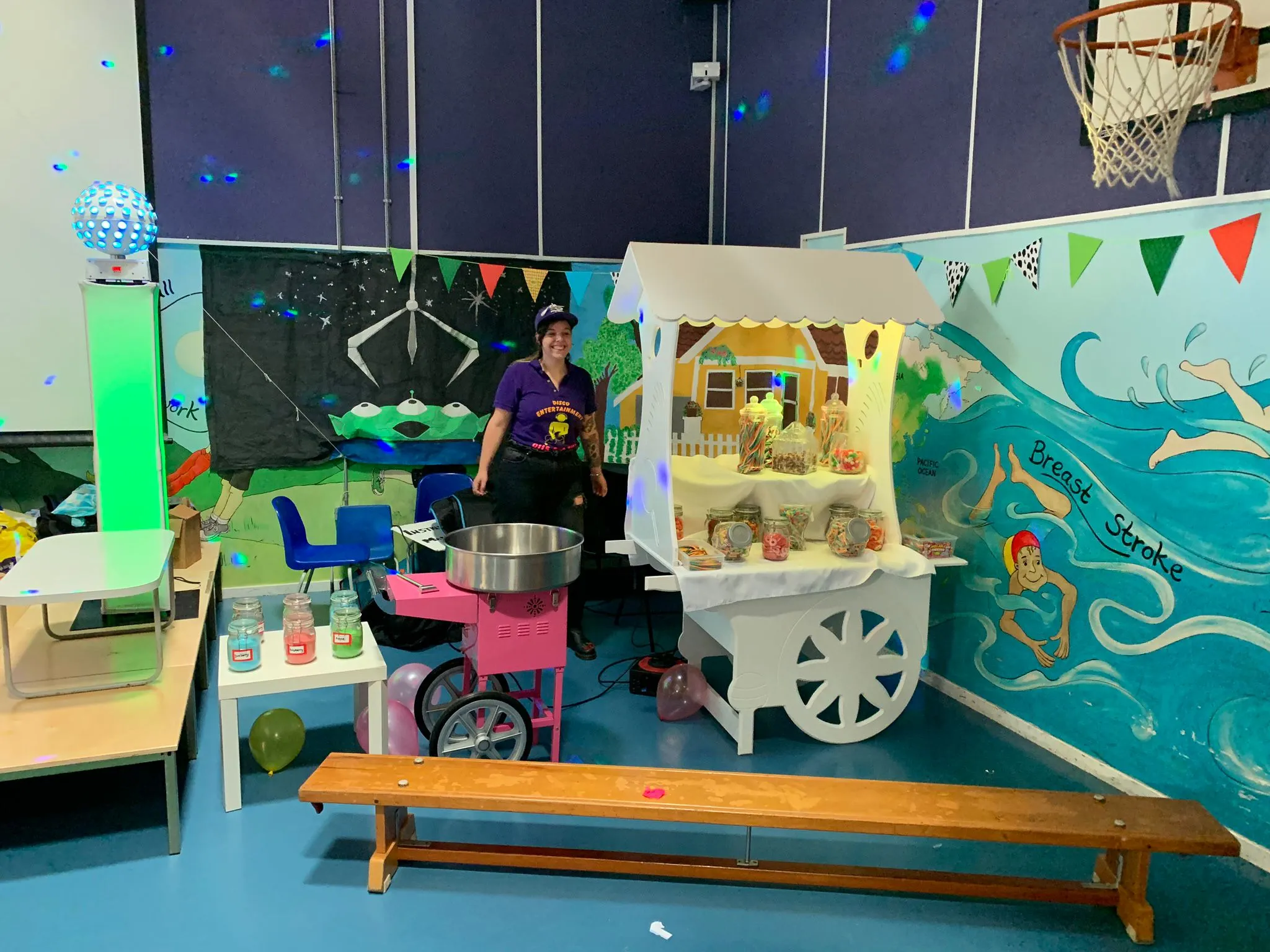 Disco Entertainers DJ with a candy floss machine and candy cart at a colourful children's party setup.