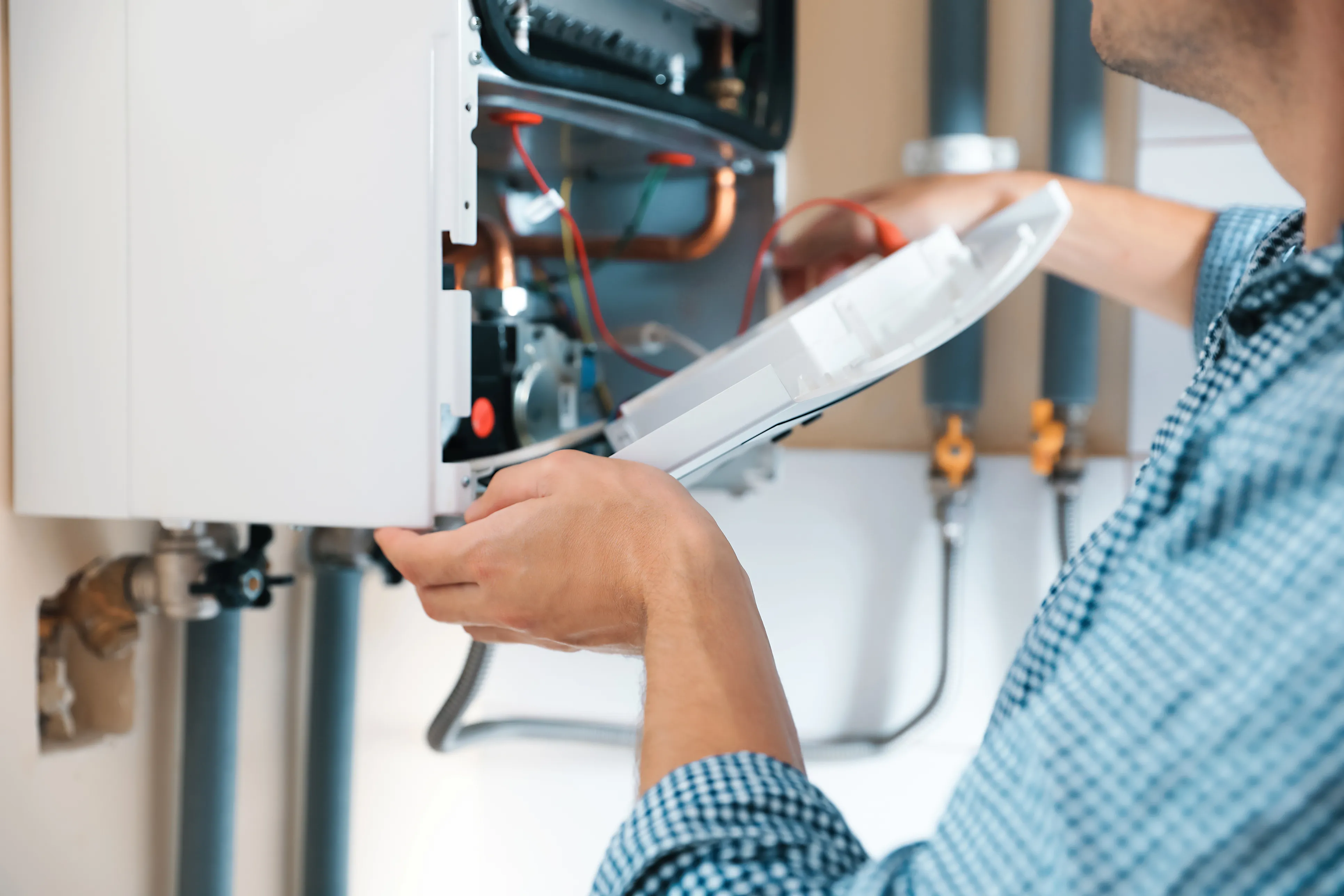 A close-up shot of a heating engineer checking the inside of a boiler.