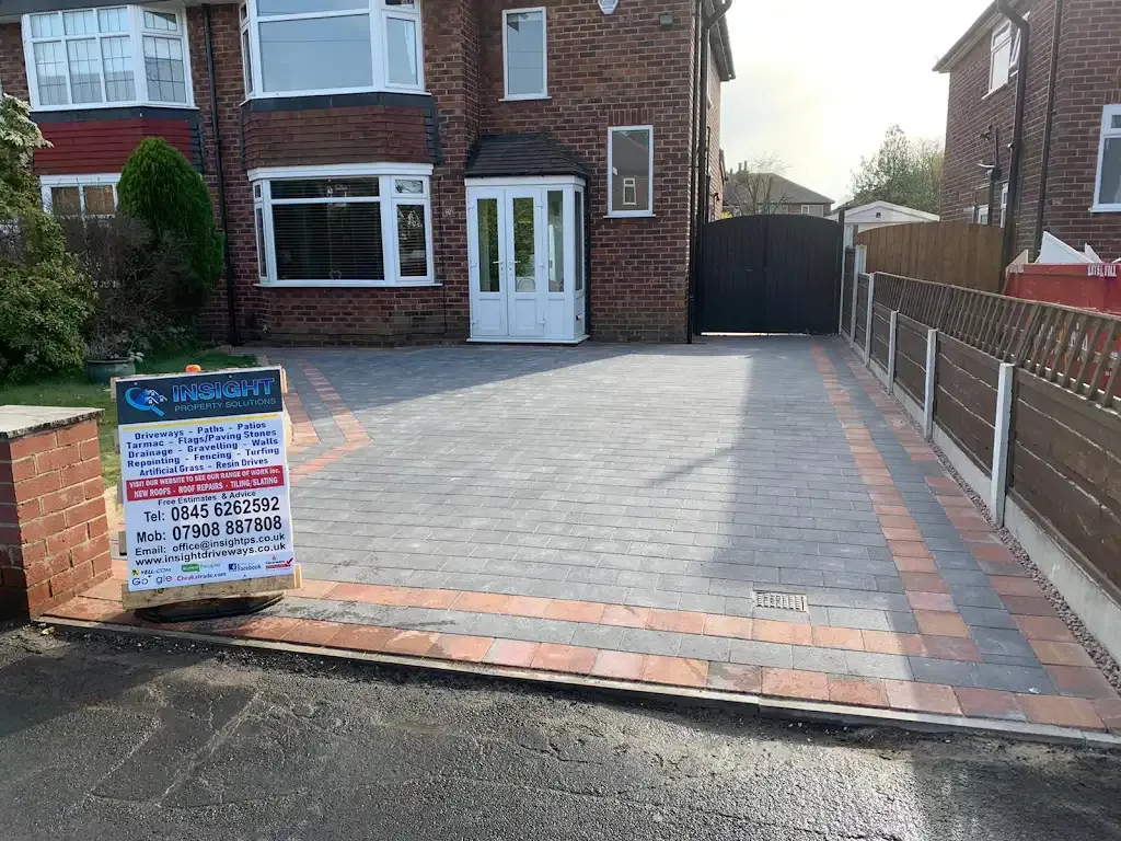 Newly installed block paving driveway with a company sign