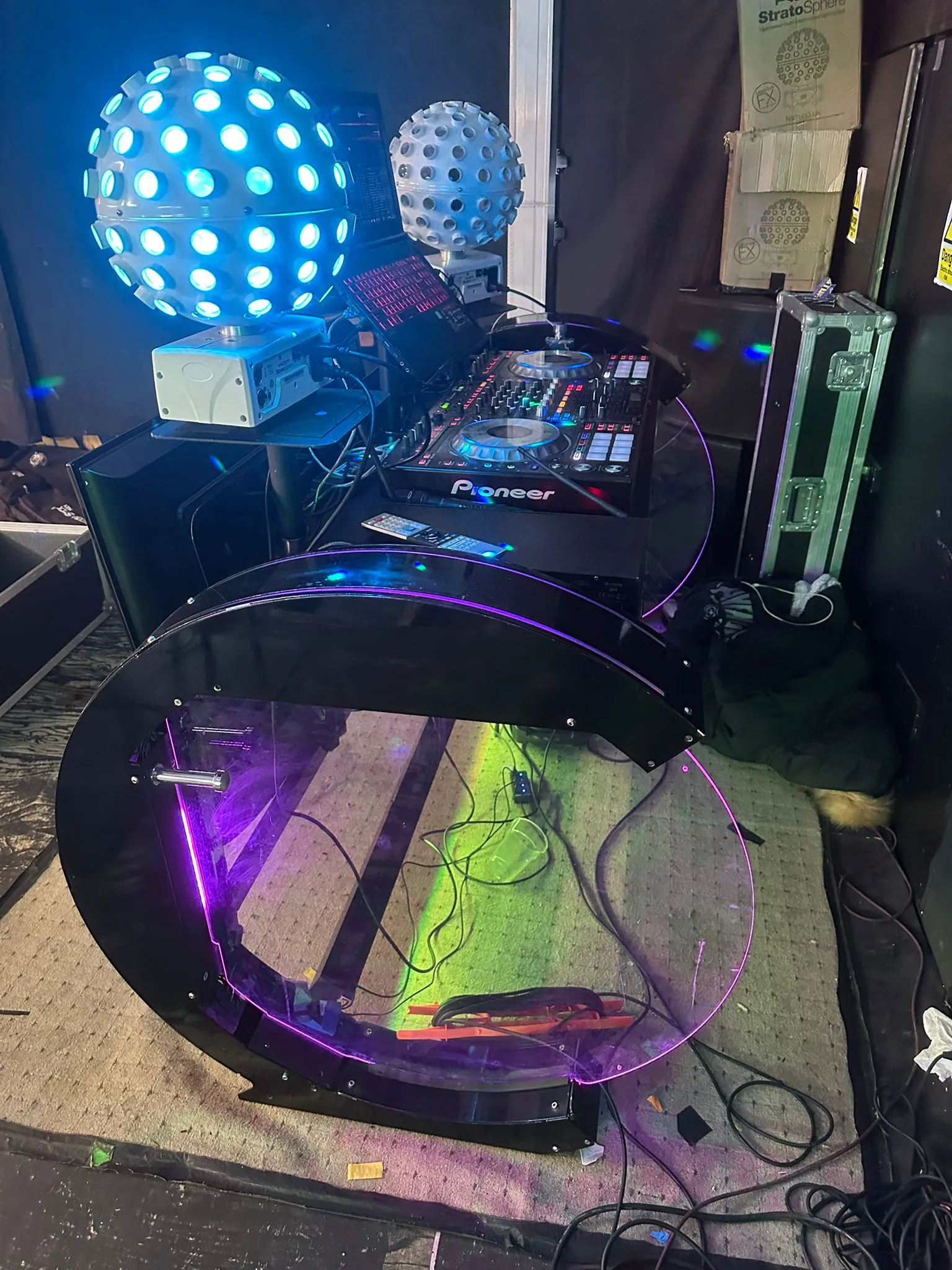 A professional DJ setup by Disco Entertainers with a Pioneer mixer, bright LED disco balls, and a purple-lit DJ booth