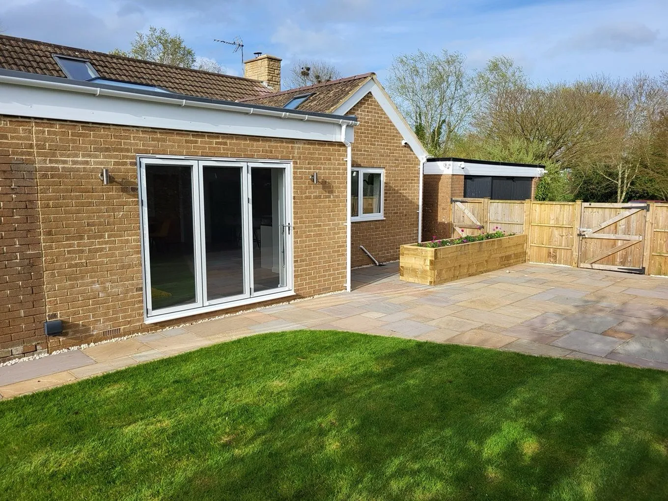 Completed home extension with bi-fold doors, patio, and garden by DP Carpentry & Building LTD in Gloucestershire