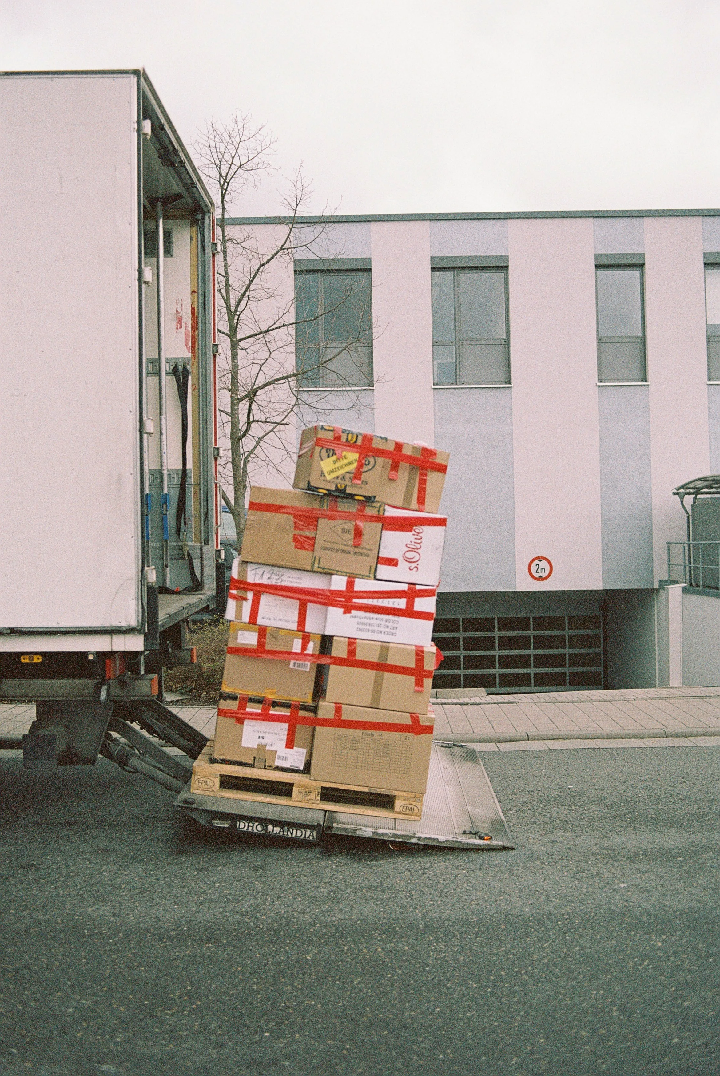 Moving boxes on a tail lift of a London removals truck.