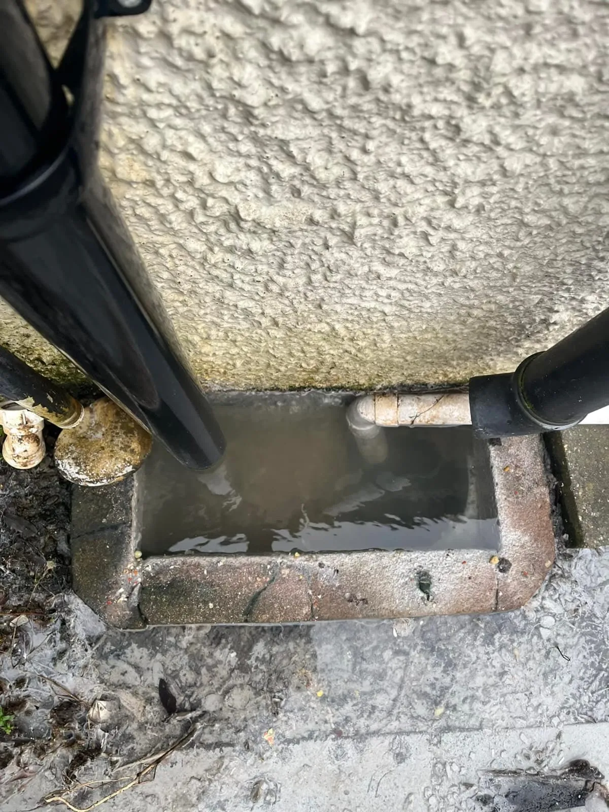 Blocked outdoor drain overflowing with water