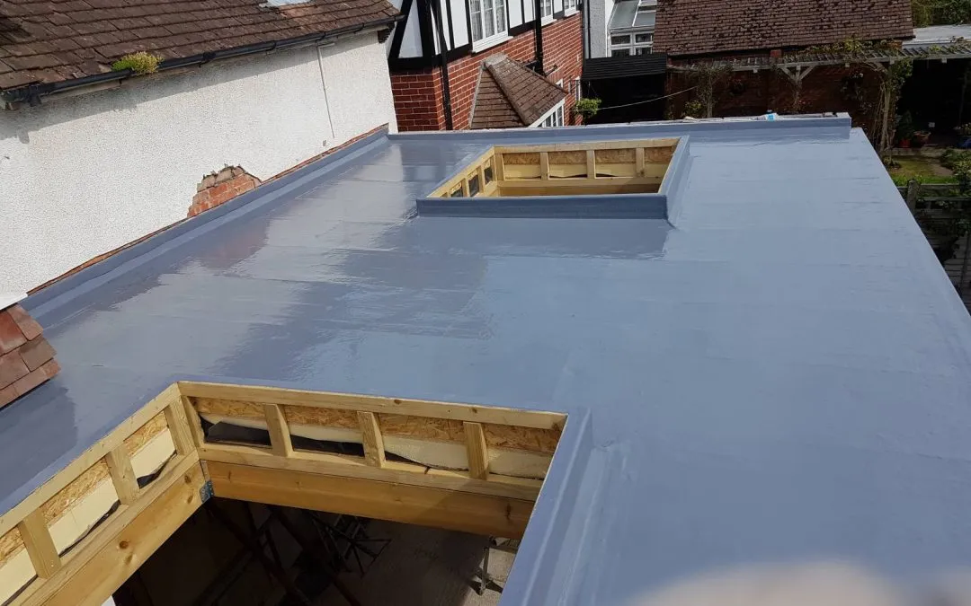 Close-up view of a modern grey flat roof surface showing timber framed openings for rooflights.
