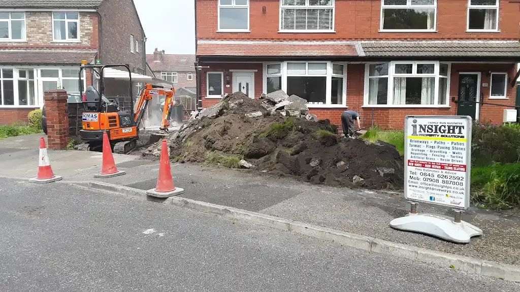 Mini-digger and ground preparation work for a driveway or patio installation.