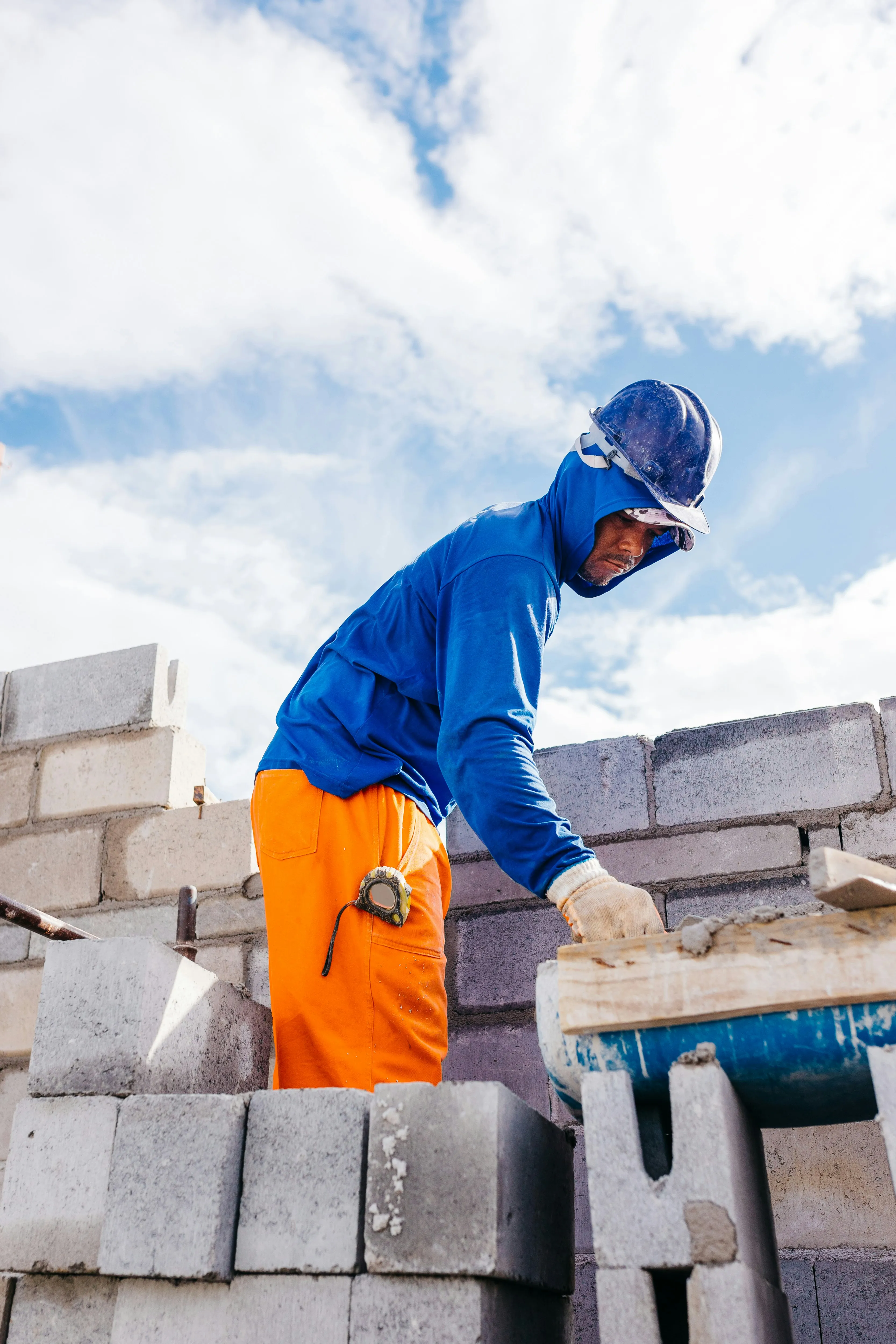 Construction worker building a wall with concrete blocks.