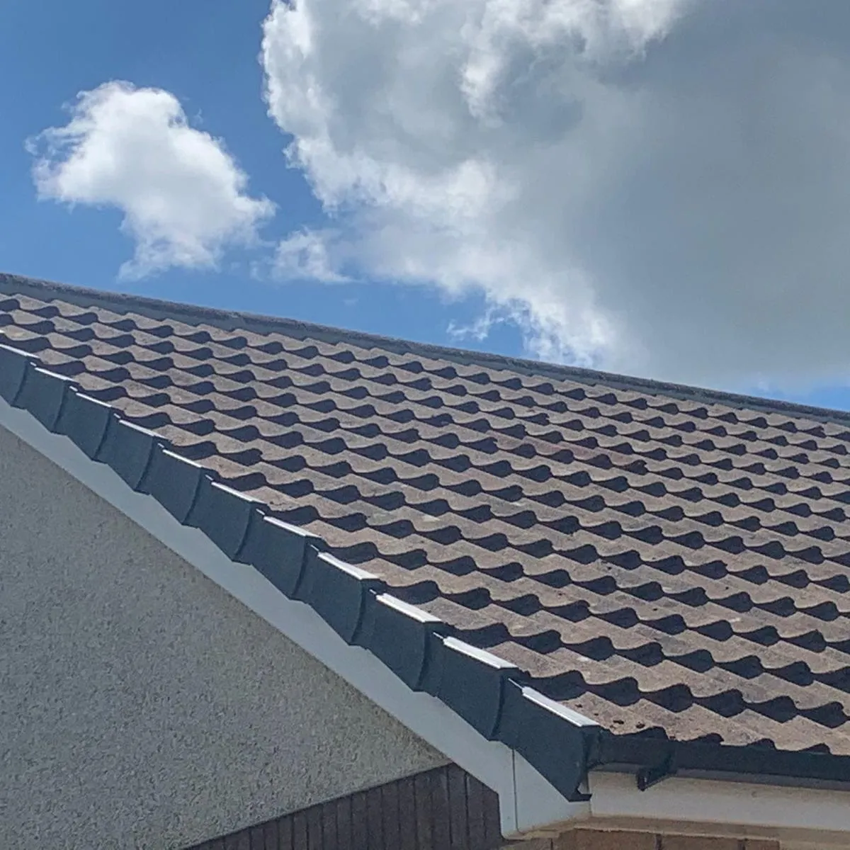 Newly installed dark interlocking roof tiles on a house roof in Kent by Century Roofing & Building.