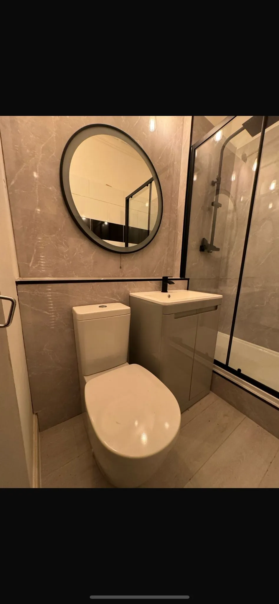 Modern residential bathroom with toilet, sink, and shower