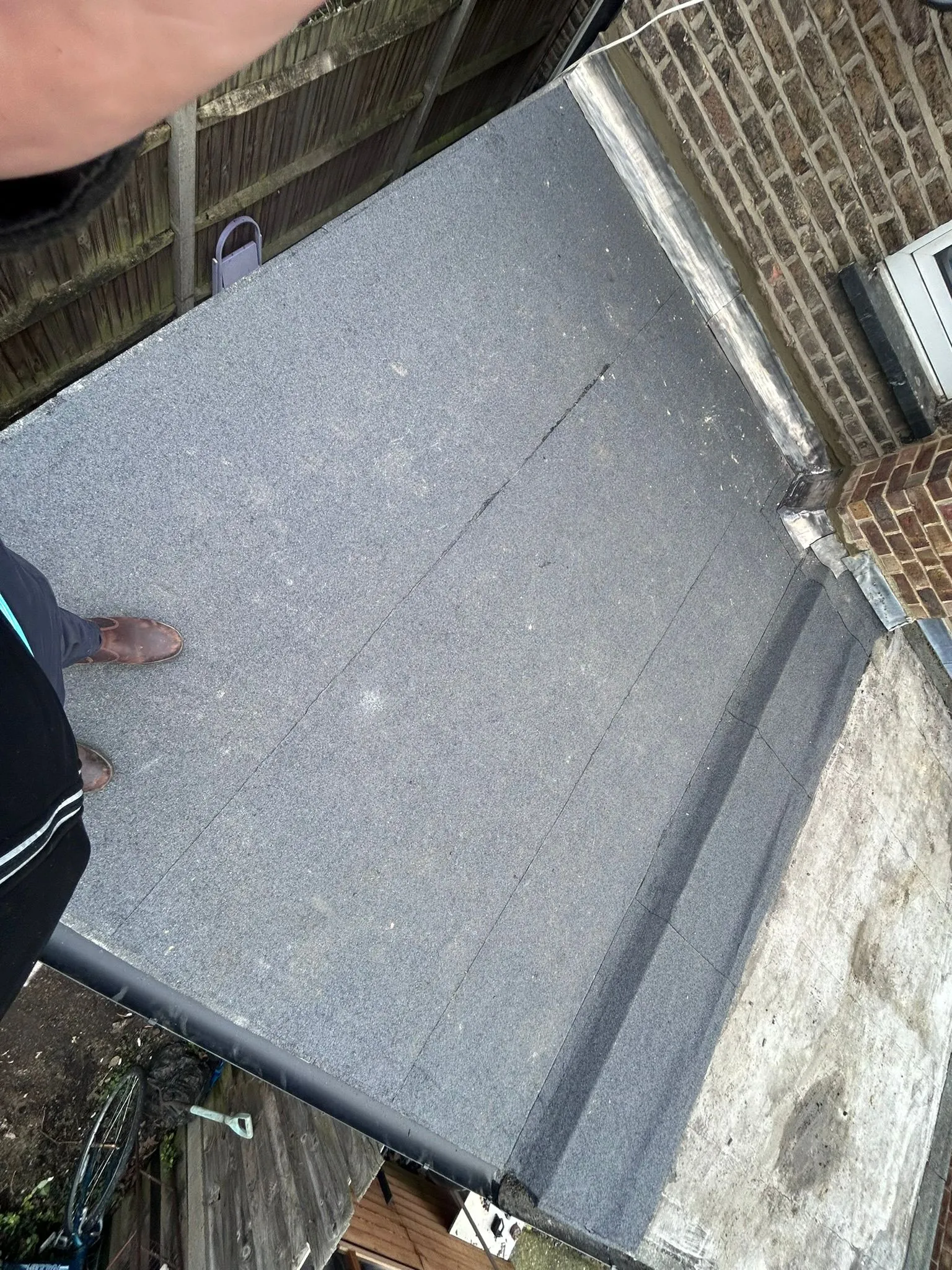 Newly installed flat felt roof with guttering