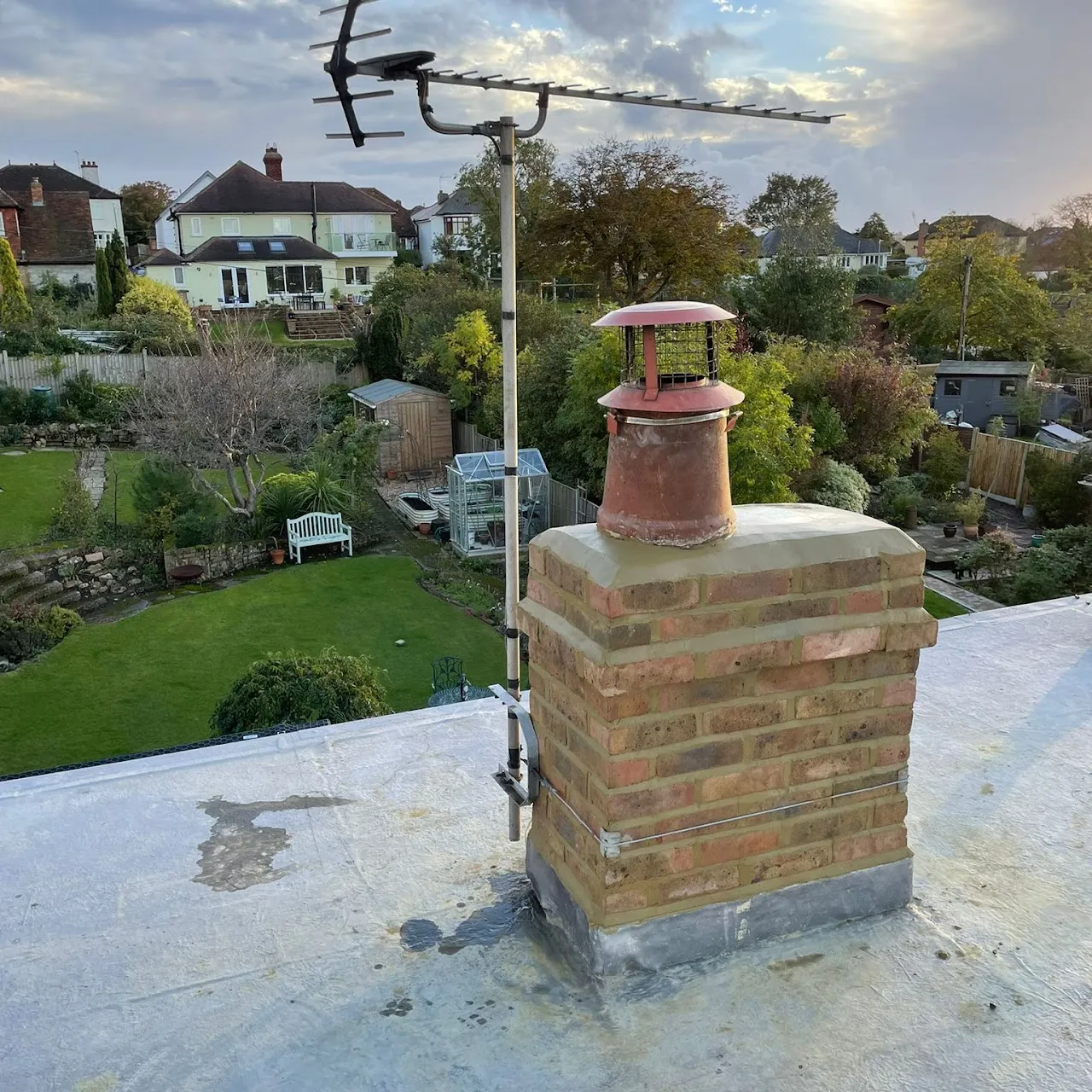 Repaired chimney with new lead flashing on a flat roof by Century Roofing and Building