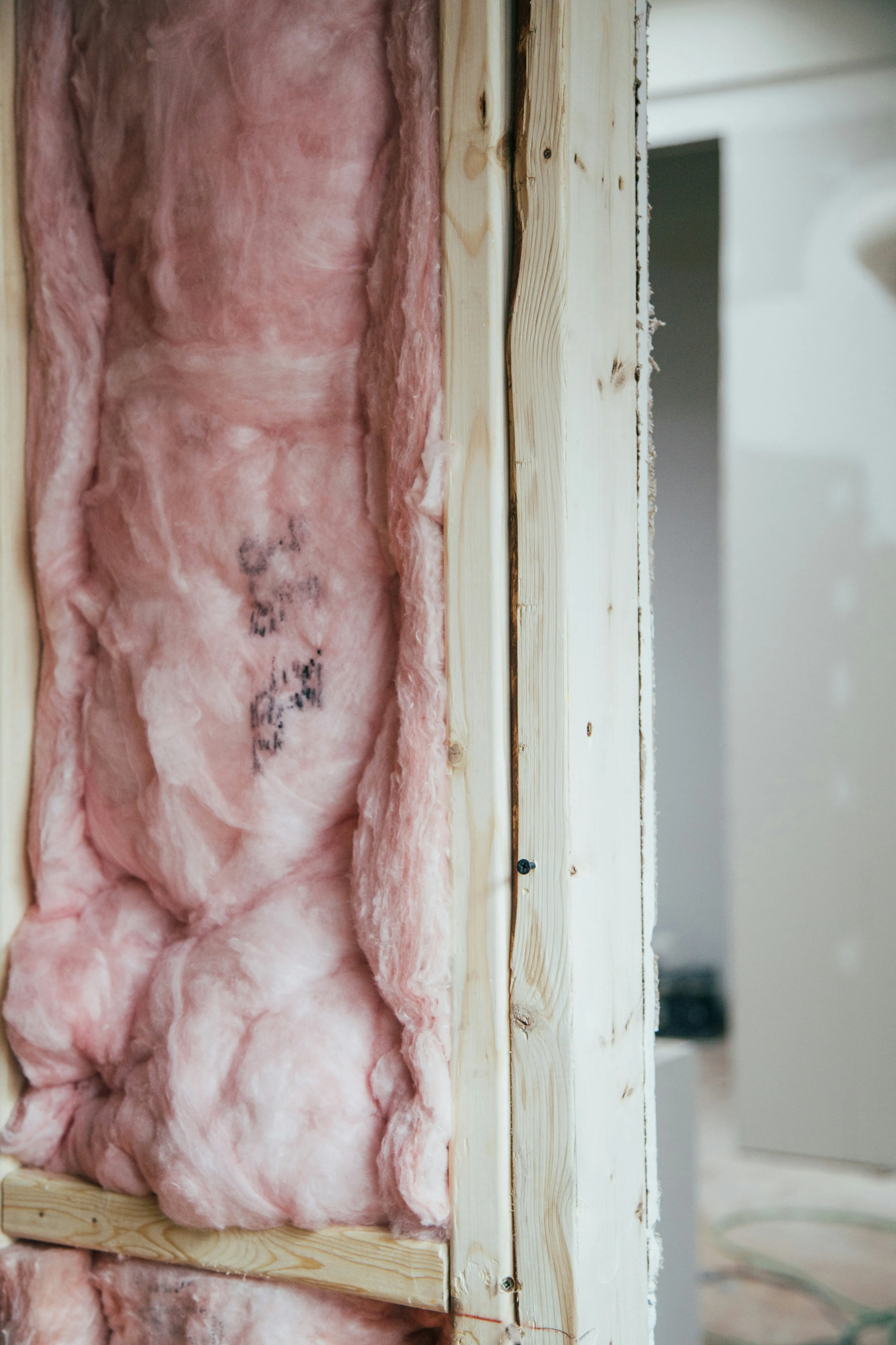 Pink insulation in a wooden wall frame