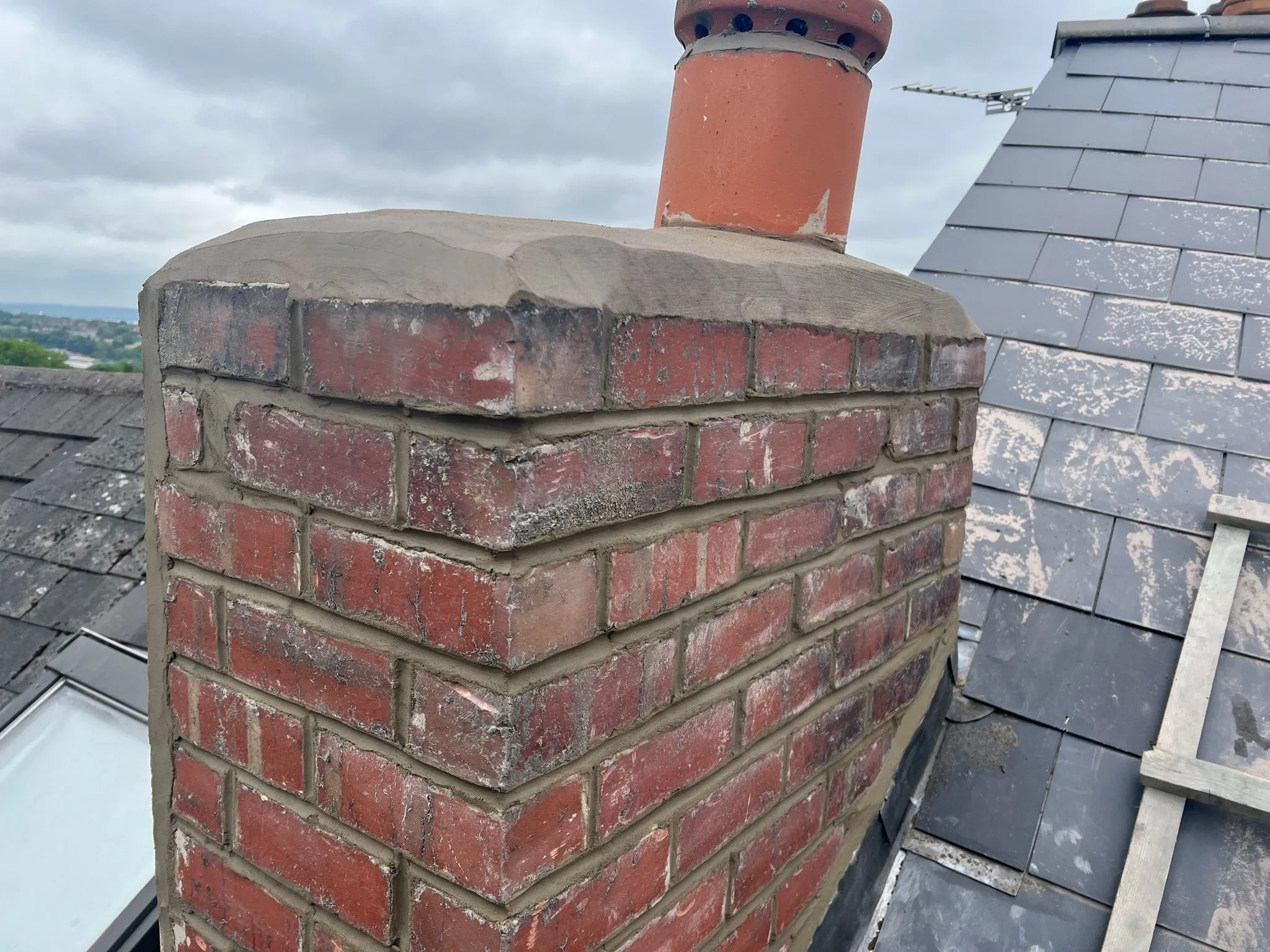 Brick chimney on roof with repaired mortar and rendering in Sheffield