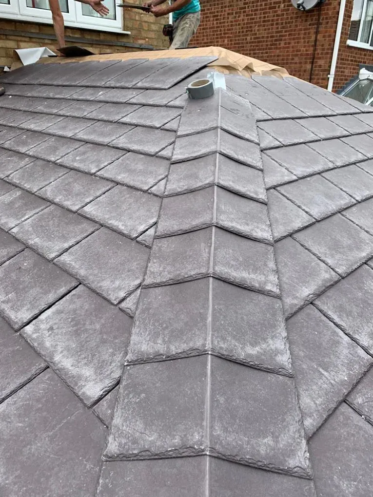 Installing a new grey tiled conservatory roof on a house