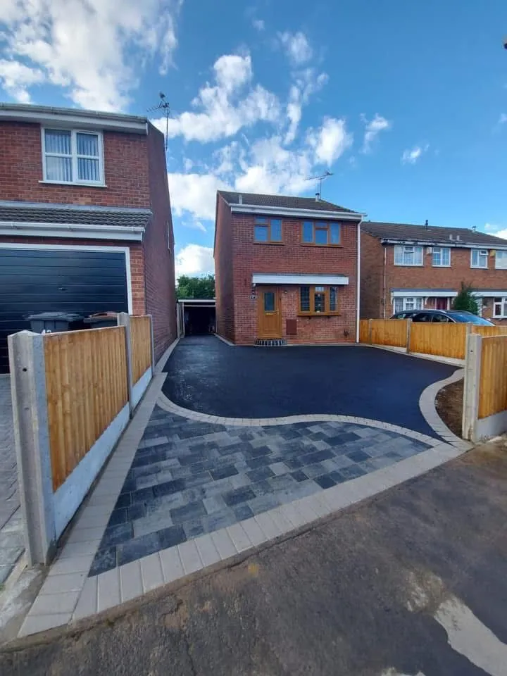 A completed multi-material driveway with tarmac and block paving, new fencing, leading to a detached house in Romford.