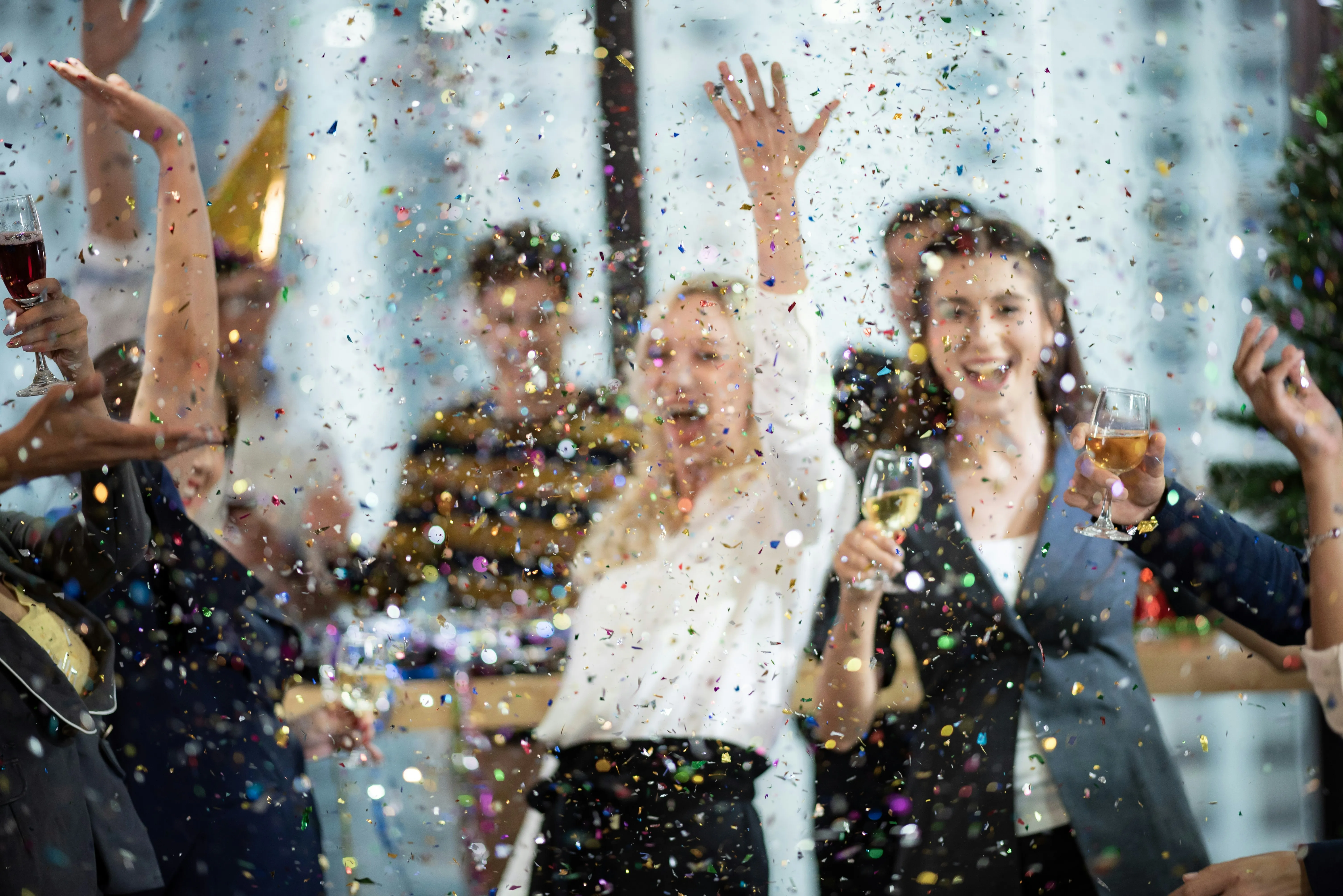 People celebrating at a party with confetti falling.