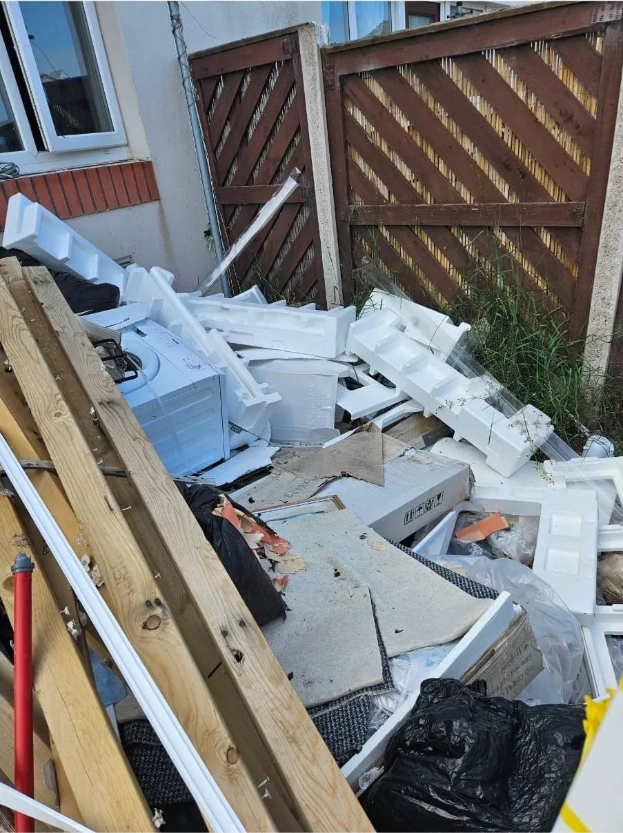 Large pile of household rubbish including a washing machine, polystyrene, and wood debris, ready for house clearance and rubbish removal service in Llandudno.