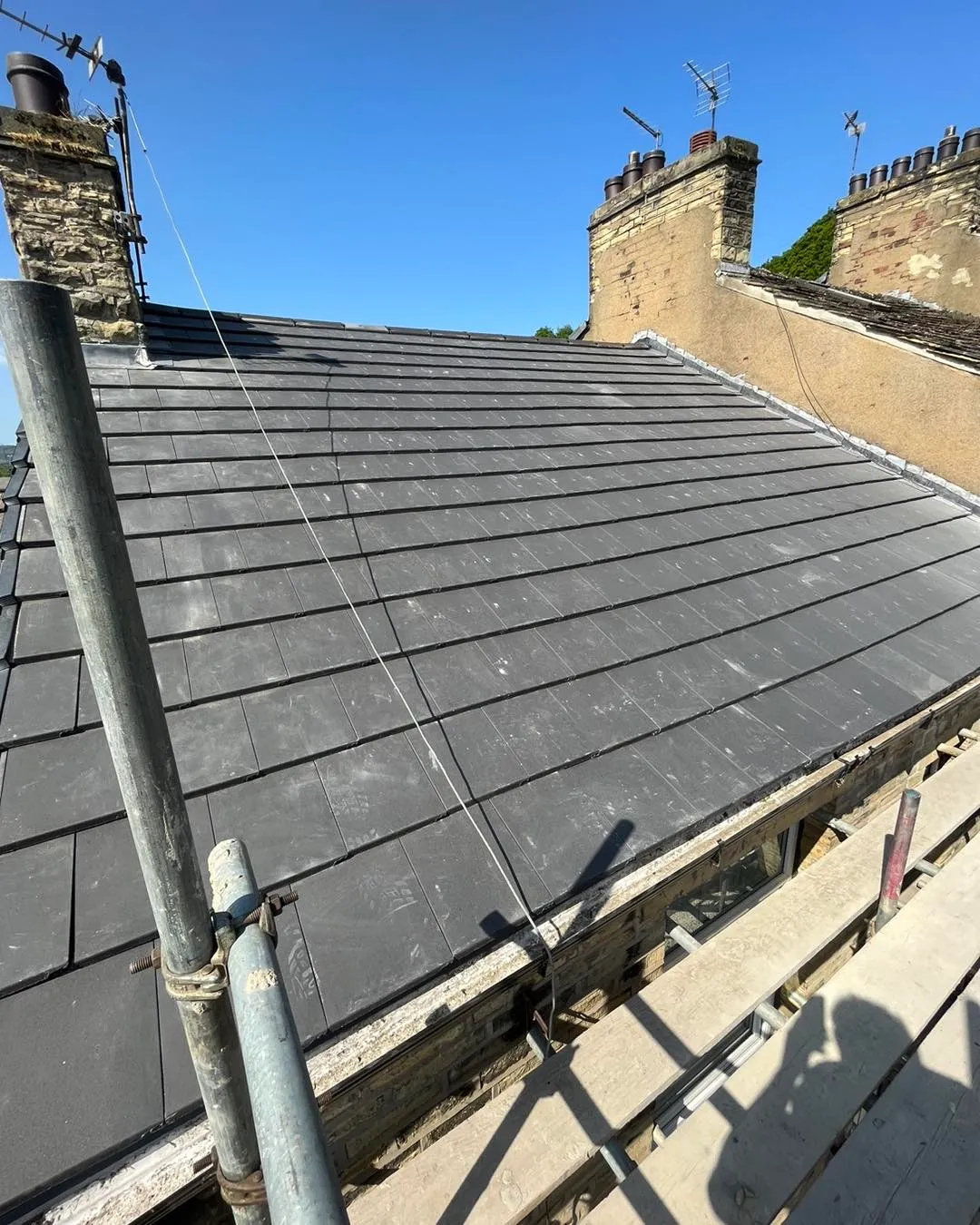 Professional installation of new roof tiles on a pitched roof by Toptile Roofing Specialists Ltd.