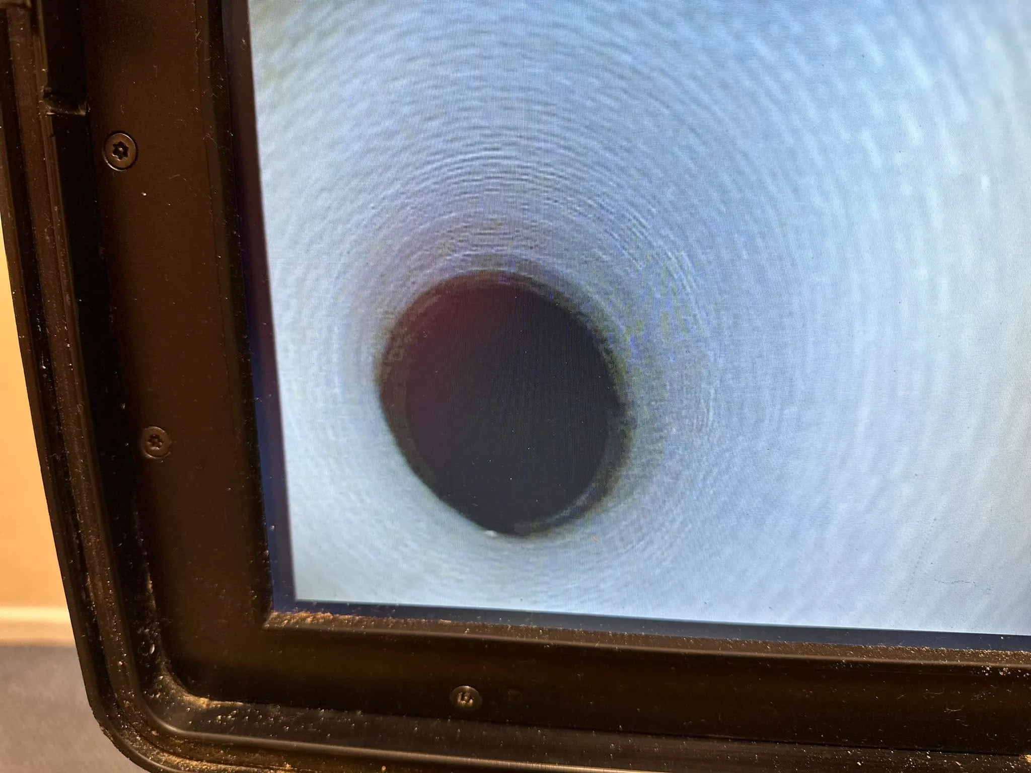 CCTV drain survey monitor displaying the inside of a clean drainage pipe.