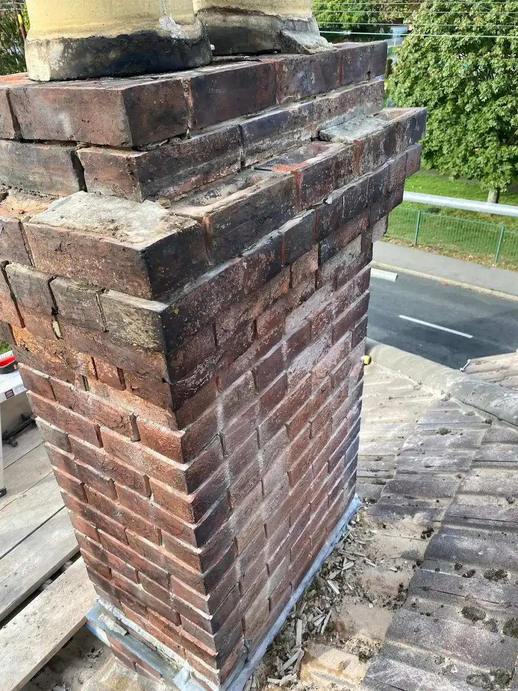 Brick chimney on a roof, showing detail of the brickwork and lead flashing