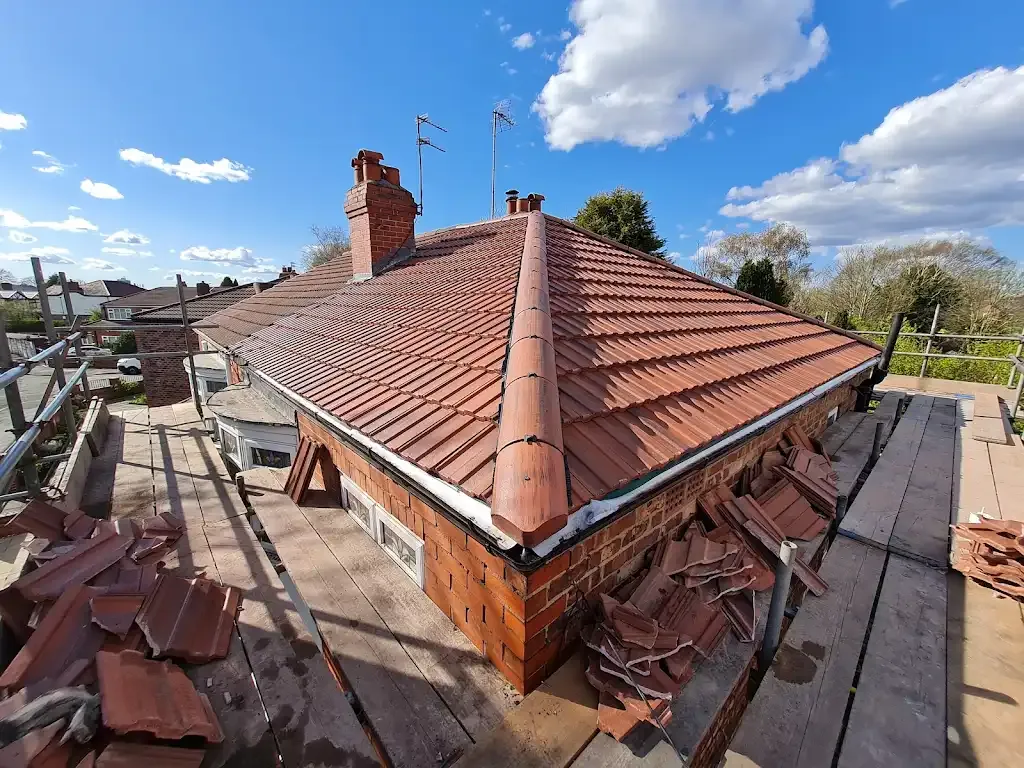 Residential tiled roof repair with scaffolding and old tiles